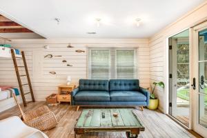 un salon avec un canapé bleu et une table dans l'établissement The Compound - 3 Cottages, à Folly Beach