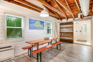 une salle à manger avec une table et un banc dans l'établissement The Compound - 3 Cottages, à Folly Beach
