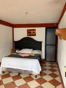 1 dormitorio con 1 cama y suelo de baldosa en Hotel Villa del Lago, Gladys, en San Pedro La Laguna