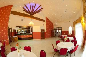 a dining room with white tables and red chairs at Hotel & Restauracja Okrąglak in Chęciny