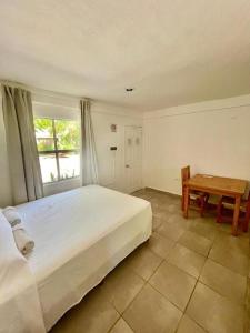 ホルボックス島にあるLa Diosa Kali Beach Front Hotelのベッドルーム1室(ベッド1台、テーブル、窓付)