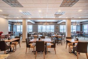 a dining room with tables and chairs and windows at Best Western Plus Flathead Lake Inn and Suites in Kalispell