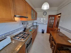 阿爾圖拉的住宿－Apartamento Praia de Altura by Homekeys，厨房配有木制橱柜和炉灶烤箱。