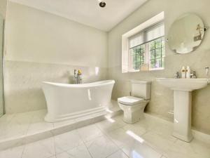 a bathroom with a tub and a toilet and a sink at Chadwell Hill Farm in Longwick