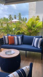 um sofá azul com almofadas coloridas num pátio em Casa Maldivas em São Miguel dos Milagres em Passo de Camarajibe