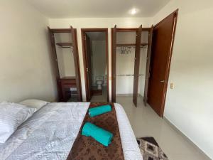 een slaapkamer met een bed met blauwe schoenen erop bij Condominio Campestre Laguna Club Cartagena in Los Arrayanes