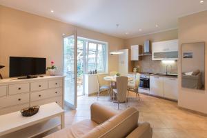 a kitchen and living room with a couch and a table at Apartmaji Koman in Bled