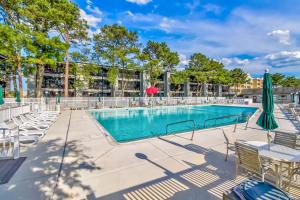 a swimming pool with chairs and umbrellas at Our Place at the Beach I-101 in Ocean City