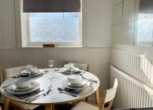 a dining room table with chairs and a window at Cheerful 2 bedroom residential home - Free parking in Leeds