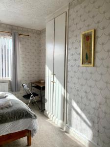 a bedroom with a bed and a desk in it at EXQUISITE FOLK VICTORIAN ONE-BED HOUSE: in Leeds