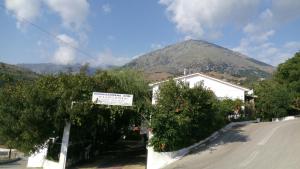 a mountain in the distance with a street and trees at Filoxenia Rooms in Makrilies