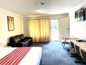 a living room with a couch and a table at Golfview Motor Inn in Wagga Wagga