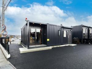 a black shipping container sitting in a parking lot at HOTEL R9 The Yard Ena in Ena