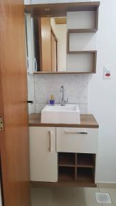 Un baño con un lavabo blanco y un espejo. en Casa 200 Arraial, en Arraial do Cabo