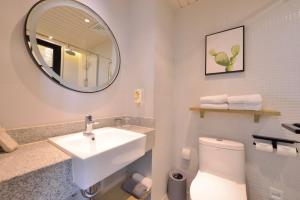 a bathroom with a sink and a mirror and a toilet at 银座精宿济南长清大学城店 in Changqing