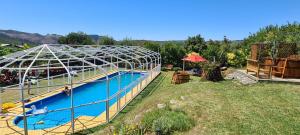 una piscina con una serra accanto a un cortile di Hotel San Giorgio a Capitán Pastene