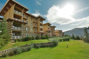 a large apartment building with a green lawn in front of it at Eliz Hotel Convention Center Thermal Spa & Wellnes in Ankara