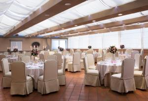 a banquet hall with white tables and white chairs at Starhotels Terminus in Naples