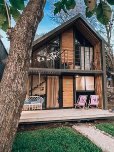 une maison avec deux chaises sur une terrasse en bois dans l'établissement Little Escape, à Santa Teresa