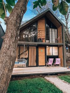 a house with two chairs on a wooden deck at Little Escape in Santa Teresa Beach