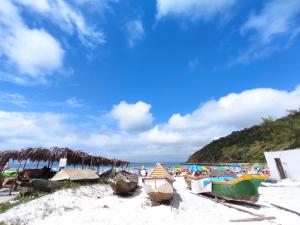 una playa con varios barcos sentados en la arena en Casa 200 Arraial, en Arraial do Cabo