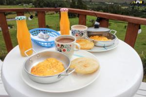 einen Tisch mit einem Teller mit Speisen und Getränken darauf in der Unterkunft Skyline Glamping Guasca in Guasca