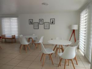 a dining room with white tables and white chairs at Hostal Doñihue in Doñihue +37 photos