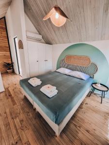 a bedroom with a bed with two towels on it at Little Escape in Santa Teresa Beach
