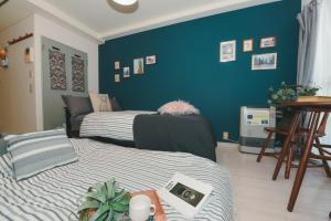 a bedroom with two beds and a blue wall at Florish 67 - Vacation STAY 15424v in Sapporo