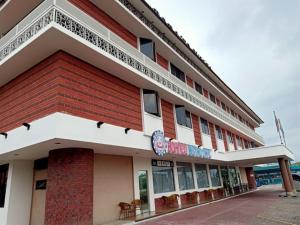 un edificio de color rojo y blanco en Super OYO 90464 Borneo Suites Hotel, en Kota Kinabalu