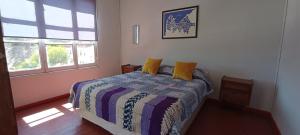 a bedroom with a bed with yellow pillows on it at Selva Hospedaje in Valparaíso