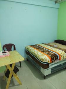 危地馬拉的住宿－HOTEL EL EDEN，一间卧室配有一张床和一张木桌