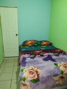 a bedroom with a bed with flowers on it at HOTEL EL EDEN in Guatemala
