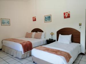 2 camas en una habitación con paredes blancas en Novohostal B&B en Guatemala