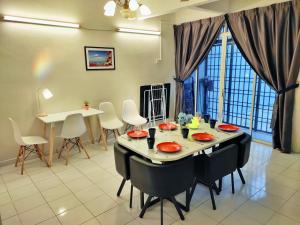 uma sala de jantar com uma mesa e cadeiras num quarto em Semi-Detached, Up to 21 Pax, 4 Bedrooms, 3 Bathrooms, 4 Car Parks em Bayan Lepas