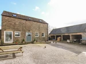 a brick building with a bench in front of it at Gratton Grange Farm- The Cottage in Bakewell