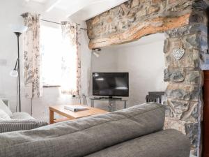 ein Wohnzimmer mit einem Sofa und einem Steinkamin in der Unterkunft Middle Cottage in Newport