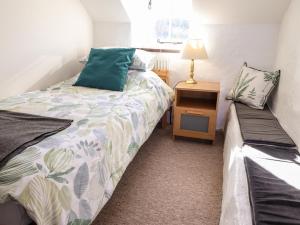 ein kleines Schlafzimmer mit einem Bett und einem Nachttisch in der Unterkunft Middle Cottage in Newport