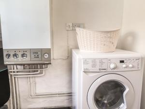 eine Waschmaschine mit einem Korb darauf in der Unterkunft End Cottage in Newport
