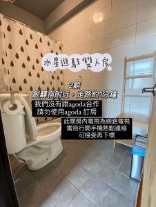 a bathroom with a toilet with writing on the wall at Original Bnb in Tainan