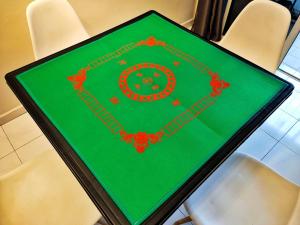 uma mesa verde com decorações vermelhas em cima das cadeiras em Semi-Detached, Up to 21 Pax, 4 Bedrooms, 3 Bathrooms, 4 Car Parks em Bayan Lepas