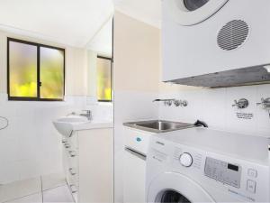 bagno bianco con lavandino e lavatrice di Sha na na Unit 3 Kings Beach Gem a Caloundra