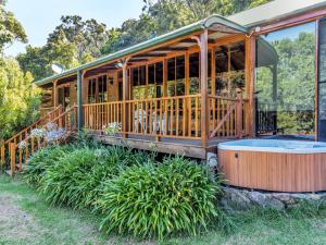 ein Haus mit einem Whirlpool im Hof in der Unterkunft Billagunyah Rainforest Retreat in Upper Kangaroo River