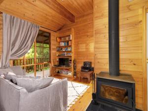 ein Wohnzimmer mit einem Kamin in einer Blockhütte in der Unterkunft Billagunyah Rainforest Retreat in Upper Kangaroo River