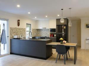 a kitchen with a counter and a table with chairs at Peaceful Bushland Retreat in Kangaroo Valley