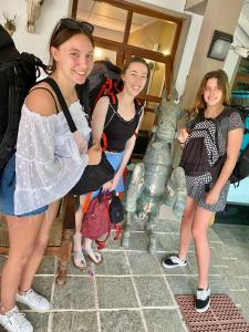 three girls are standing next to a statue at Settle Inn Tourist Lodge in Kandy