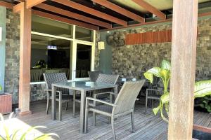 a patio with a table and chairs on a deck at The Yani Hotel Bali in Denpasar