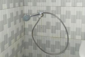 La salle de bains est pourvue d'une douche avec un pommeau de douche. dans l'établissement Habieb Homestay Syariah near Fakultas Kedokteran Universitas Malikussaleh Mitra RedDoorz, à Kadang