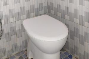 a bathroom with a white toilet in a room at Habieb Homestay Syariah near Fakultas Kedokteran Universitas Malikussaleh Mitra RedDoorz in Kadang
