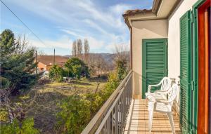 two white chairs sitting on the porch of a house at Nice Home In Belmonte In Sabina With House A Panoramic View in Rocca Sinibalda